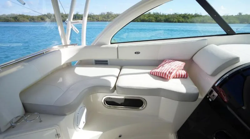Slide: The Image of 2014 Pursuit OS 345 Offshore boat interior with white seating and striped pillow. - 26