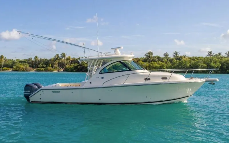 Slide: The Image of 2014 Pursuit OS 345 Offshore boat on turquoise water, with lush greenery in the background. - 3