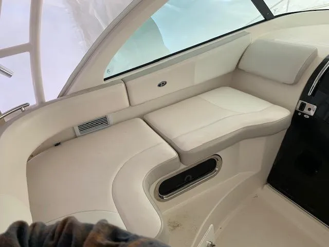 Slide: The Image of 2014 Pursuit OS 345 Offshore boat interior with white seating and window view. - 30