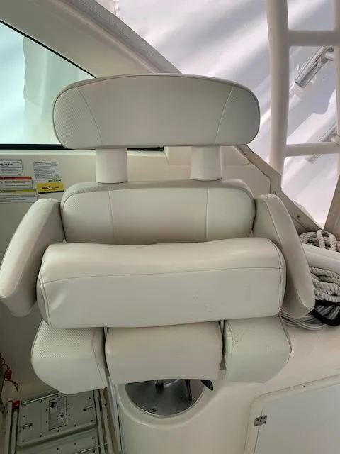 Slide: The Image of White captain's chair on 2014 Pursuit OS 345 Offshore boat, featuring plush cushioning. - 32