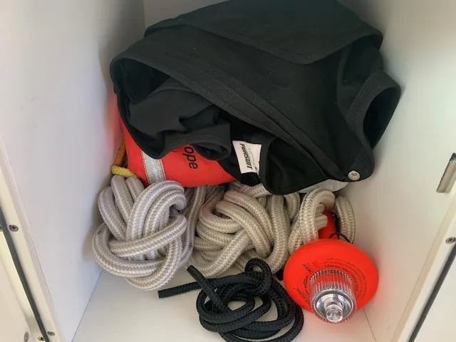 Slide: The Image of Storage compartment with ropes, life jacket, and safety equipment on a 2014 Pursuit OS 345 Offshore. - 35