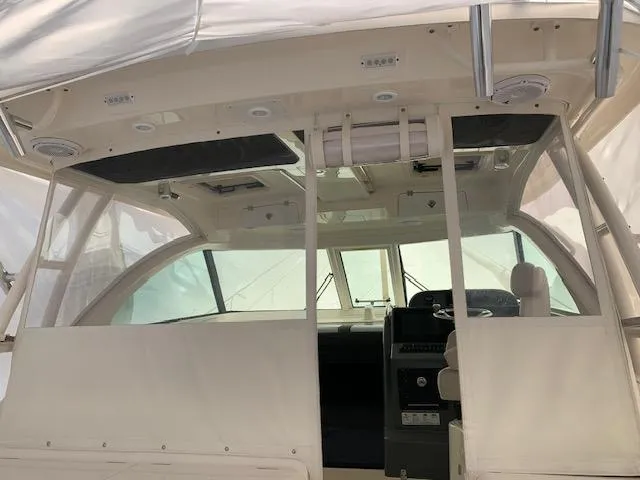 Slide: The Image of 2014 Pursuit OS 345 Offshore boat interior with helm and seating area. - 38