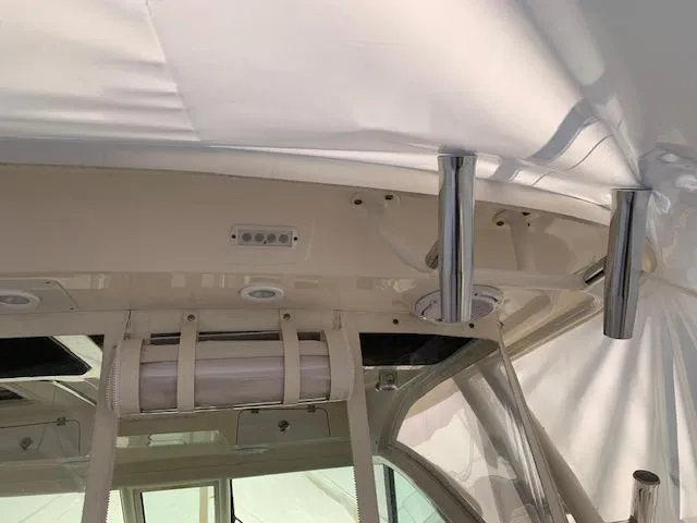 Slide: The Image of 2014 Pursuit OS 345 Offshore boat interior with rod holders and storage compartment. - 39