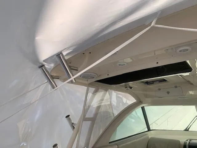 Slide: The Image of 2014 Pursuit OS 345 Offshore boat interior with protective cover and visible seating area. - 40