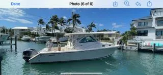 Slide: The Image of 2014 Pursuit OS 345 Offshore boat docked in a sunny marina. - 7