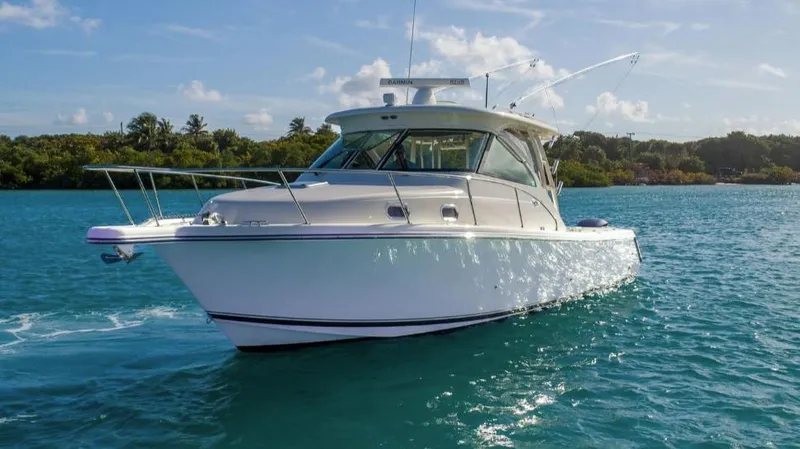 Slide: The Image of 2014 Pursuit OS 345 Offshore boat cruising on clear blue water. - 8