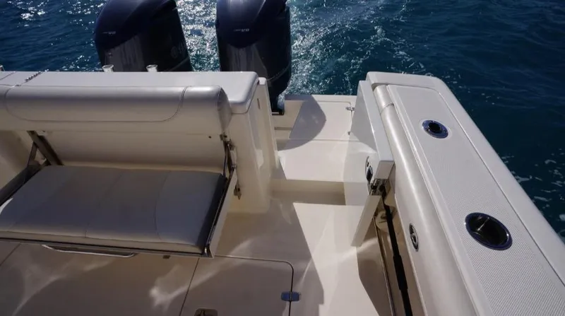 Slide: The Image of 2014 Pursuit OS 345 Offshore boat deck with seating and dual engines on water. - 9