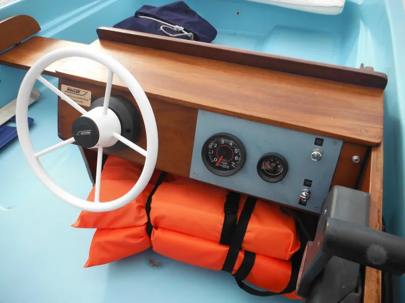 Slide: The Image of 1998 Boston Whaler 13 Sport boat dashboard with steering wheel and life jackets. - 11