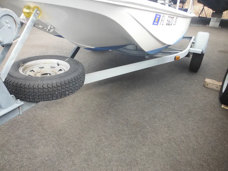 Slide: The Image of 1998 Boston Whaler 13 Sport boat on trailer, parked on asphalt. - 12