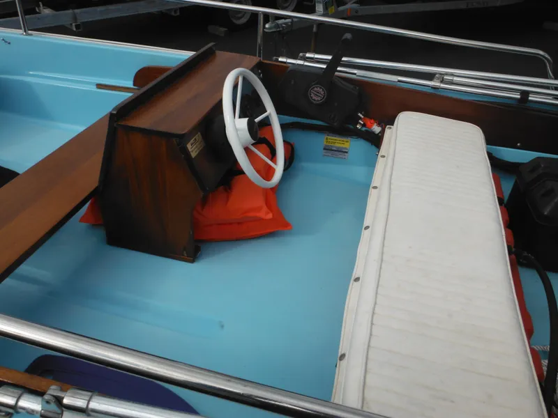 Slide: The Image of 1998 Boston Whaler 13 Sport boat interior with white steering wheel and seating. - 16