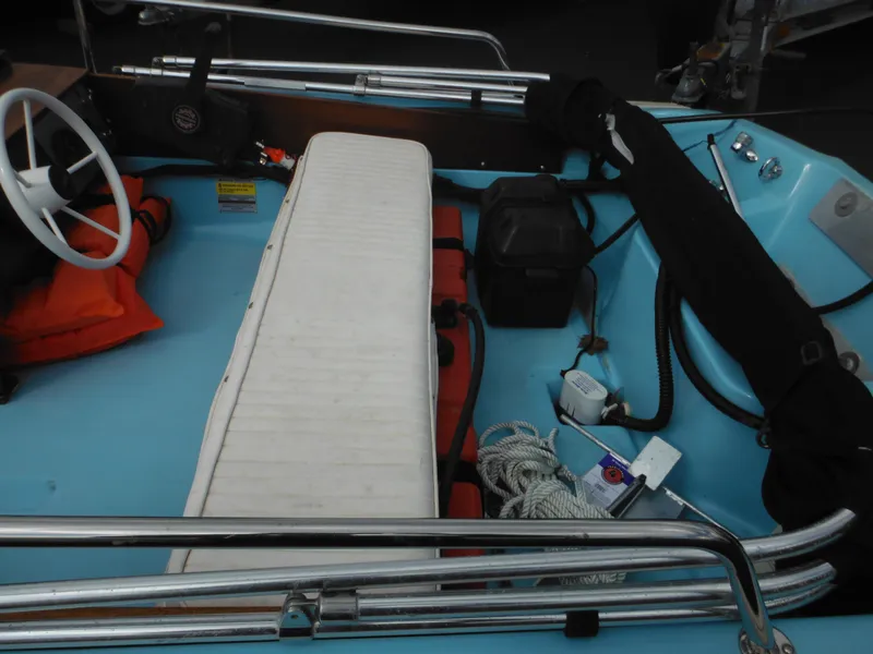 Slide: The Image of 1998 Boston Whaler 13 Sport interior with white seating and safety equipment. - 17