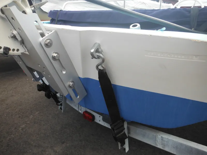 Slide: The Image of 1998 Boston Whaler 13 Sport boat on trailer, showing stern details and securing strap. - 34