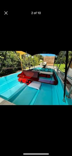 Slide: The Image of 1998 Boston Whaler 13 Sport boat with blue interior and canopy, docked outdoors. - 41