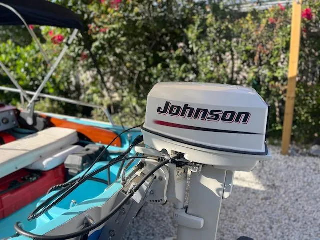Slide: The Image of 1998 Boston Whaler 13 Sport with Johnson outboard motor, surrounded by greenery. - 45