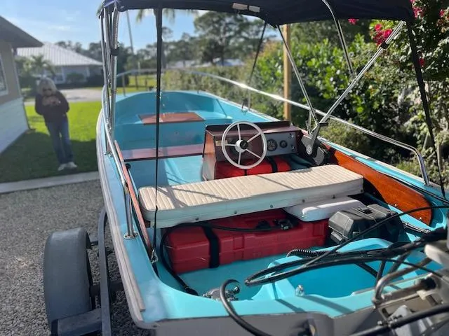 Slide: The Image of 1998 Boston Whaler 13 Sport boat on trailer, featuring blue interior and steering wheel. - 46