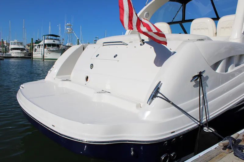 Slide: The Image of 2005 Sea Ray 340 Sundancer docked, featuring spacious deck and American flag. - 10