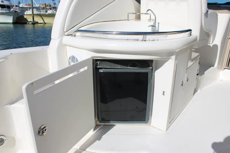Slide: The Image of 2005 Sea Ray 340 Sundancer boat kitchenette with sink and mini fridge. - 16