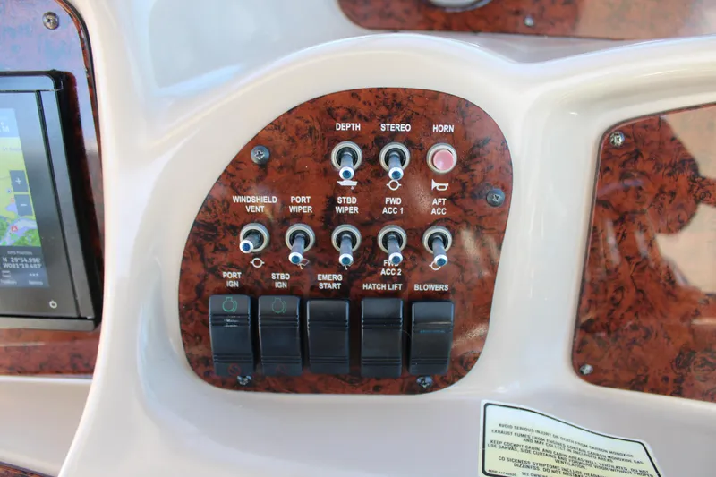 Slide: The Image of Control panel of a 2005 Sea Ray 340 Sundancer boat with various switches and buttons. - 21