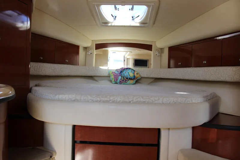 Slide: The Image of Interior cabin of 2005 Sea Ray 340 Sundancer with plush bedding and wooden cabinetry. - 28
