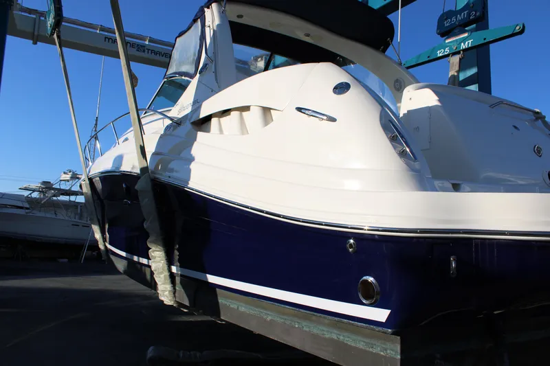 Slide: The Image of 2005 Sea Ray 340 Sundancer boat on lift, showcasing sleek design and blue hull. - 5