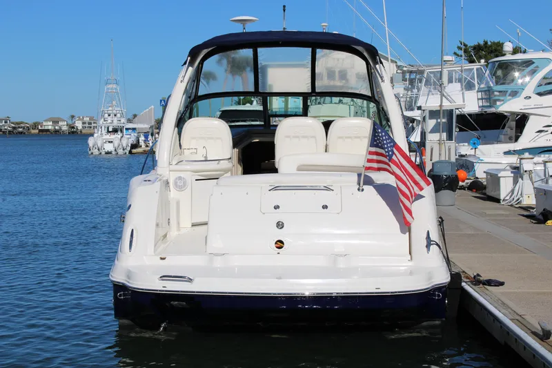 Slide: The Image of 2005 Sea Ray 340 Sundancer docked, rear view with American flag, in a marina setting. - 8