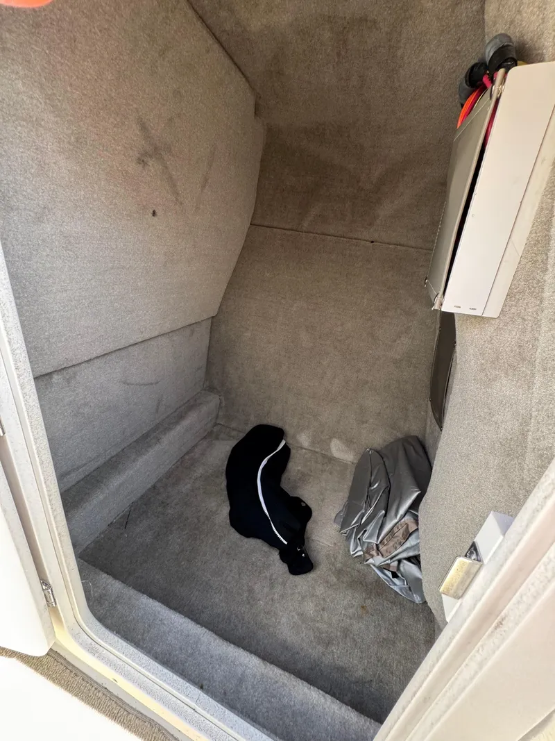Slide: The Image of Interior cabin of 2008 Crownline 270 BR boat, featuring carpeted flooring and storage items. - 13