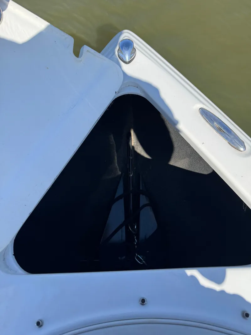 Slide: The Image of 2008 Crownline 270 BR boat anchor compartment, open lid, on calm water. - 14