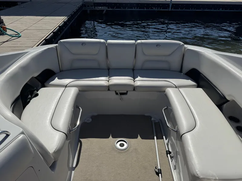 Slide: The Image of 2008 Crownline 270 BR boat interior with gray seating and dockside view. - 15