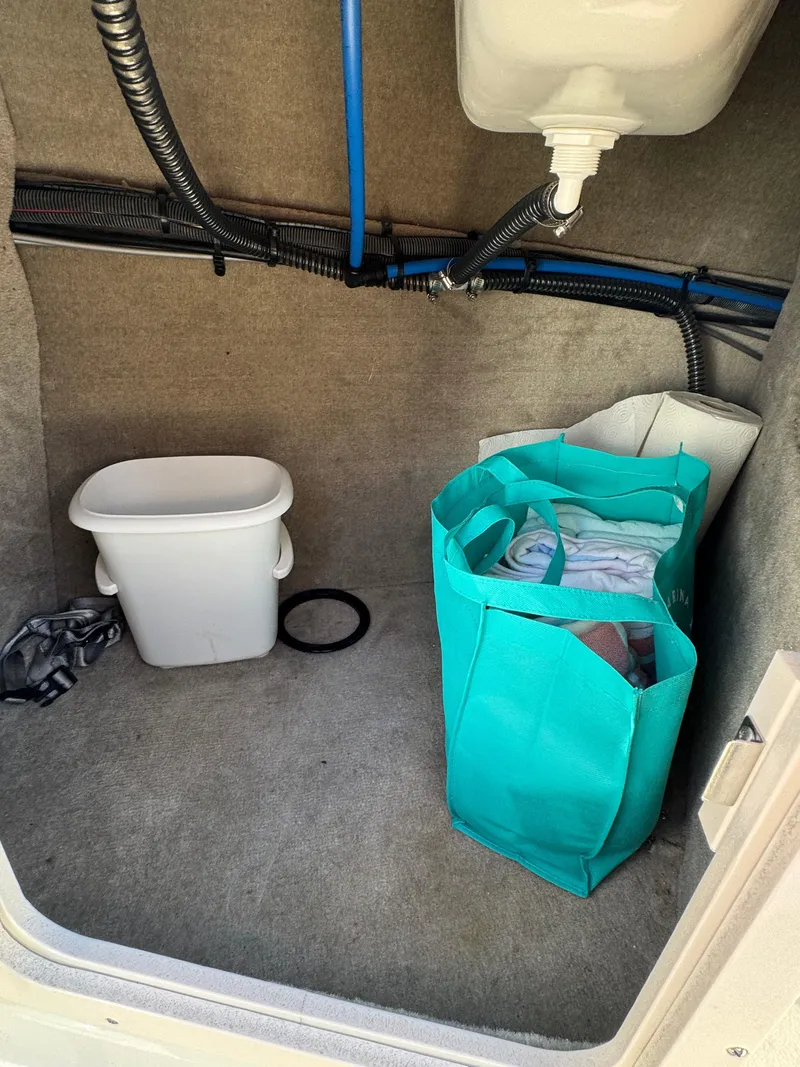 Slide: The Image of Storage area in a 2008 Crownline 270 BR boat with a bag and trash bin. - 16