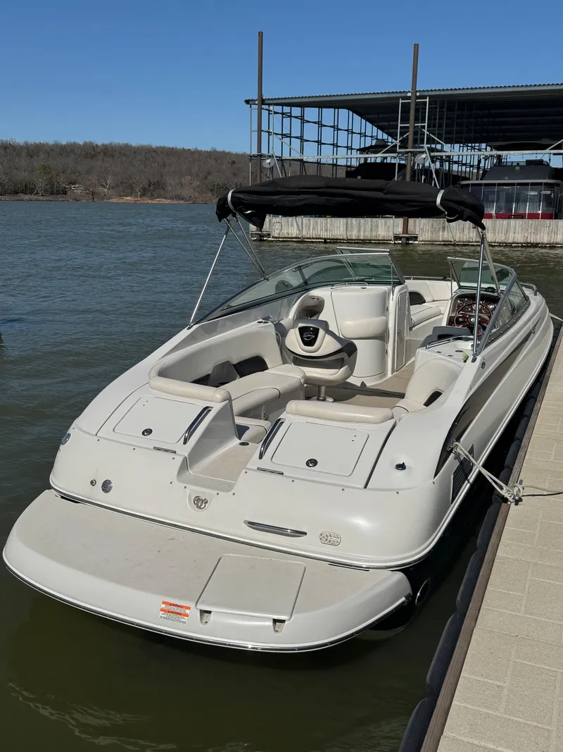 Slide: The Image of 2008 Crownline 270 BR boat docked on a sunny day, featuring spacious seating and canopy. - 8