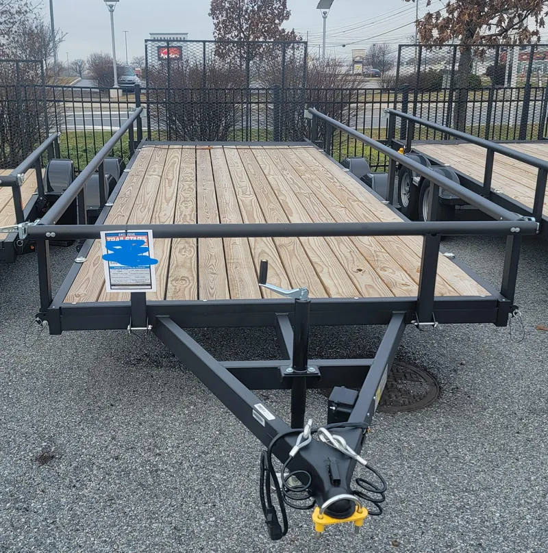 The Image of 2024 Tracker KTO-6500-82-18 utility trailer with wooden deck and metal frame. - 0