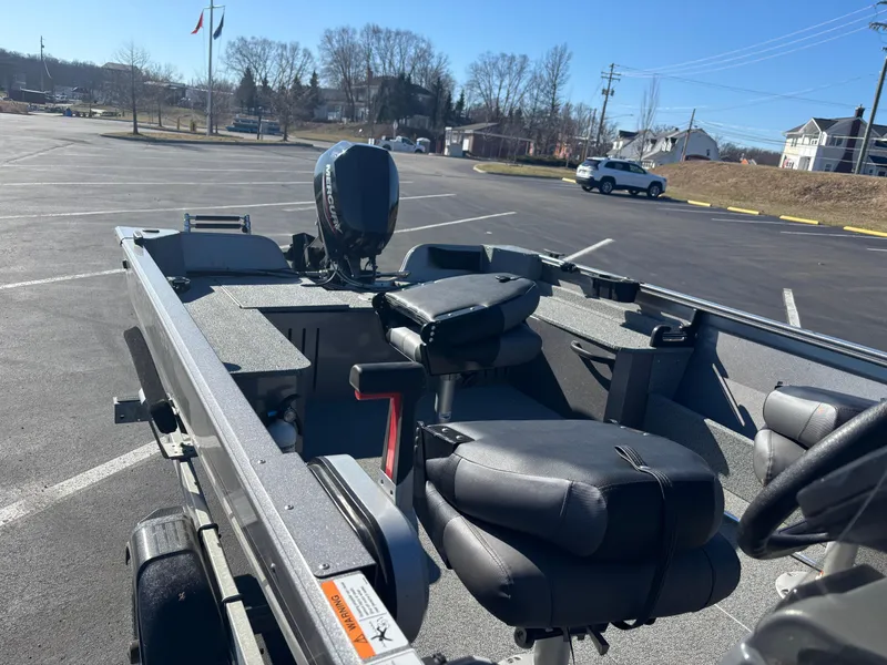 Slide: The Image of 2021 Crestliner 1650 Discovery SC boat in parking lot, featuring seating and motor. - 10