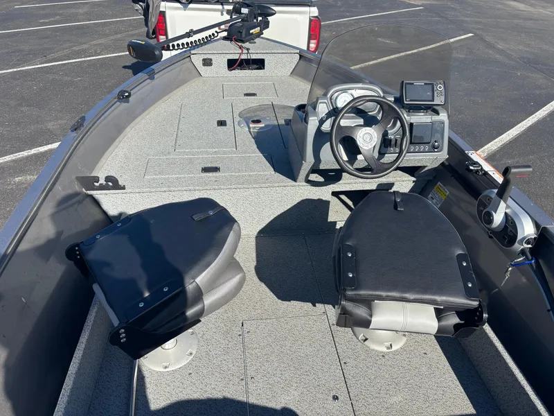 Slide: The Image of 2021 Crestliner 1650 Discovery SC boat interior with steering wheel and seating. - 2