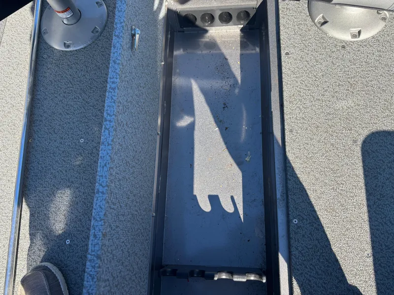 Slide: The Image of 2021 Crestliner 1650 Discovery SC boat interior, showing storage compartment and textured flooring. - 3