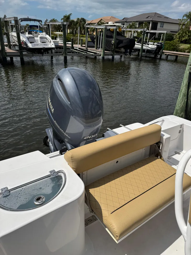 Slide: The Image of 2022 Sportsman Open 212 Center Console boat docked, featuring tan seating and Yamaha outboard motor. - 14