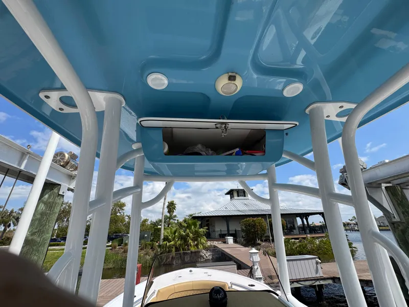 Slide: The Image of 2022 Sportsman Open 212 Center Console boat with blue T-top and dock view. - 16