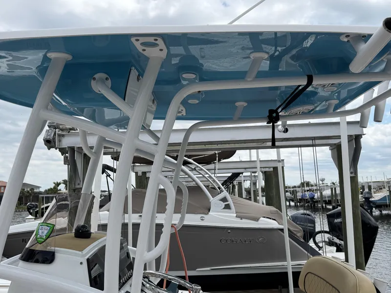 Slide: The Image of 2022 Sportsman Open 212 Center Console boat with blue T-top in marina setting. - 17