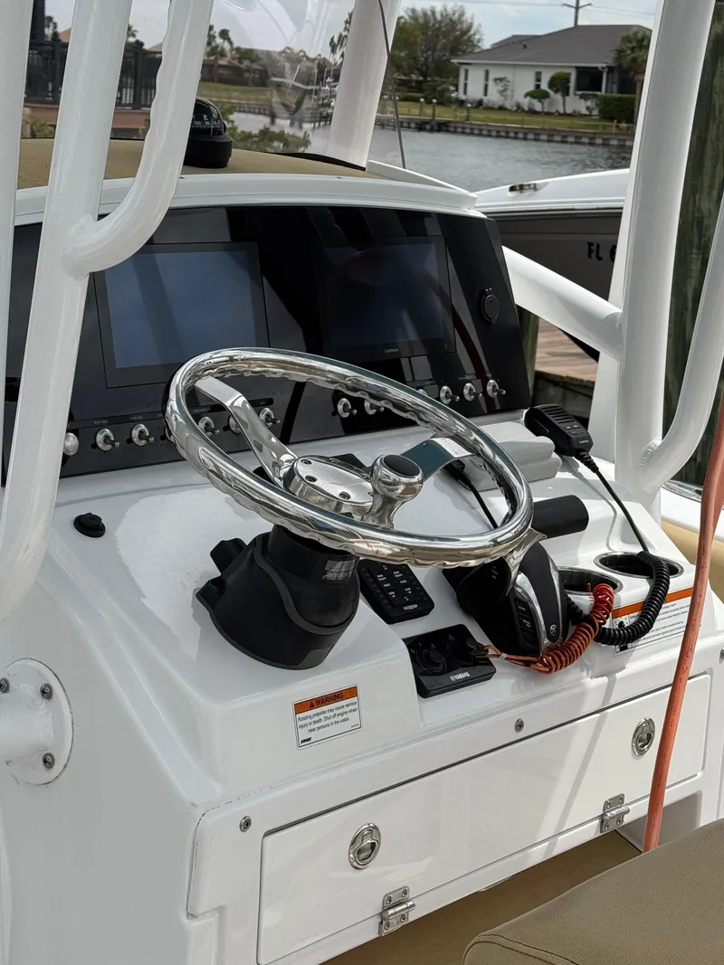 Slide: The Image of 2022 Sportsman Open 212 Center Console boat dashboard with steering wheel and controls. - 5