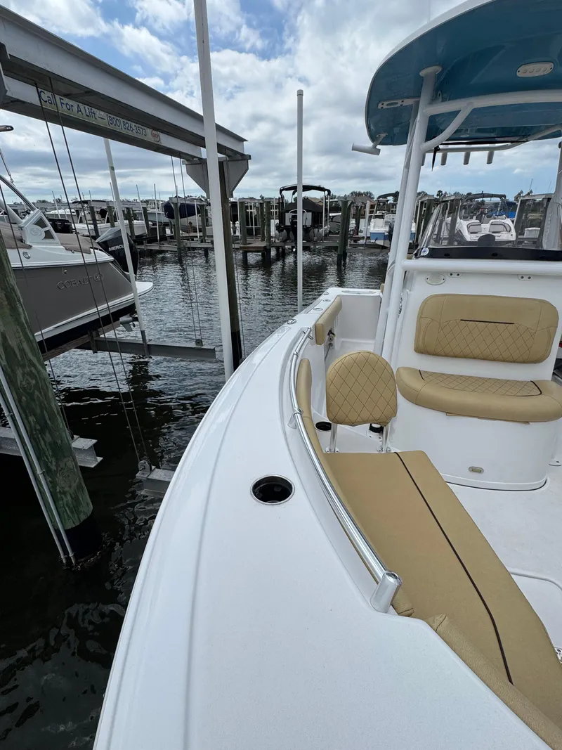 Slide: The Image of 2022 Sportsman Open 212 Center Console boat docked at marina, featuring beige seating. - 6