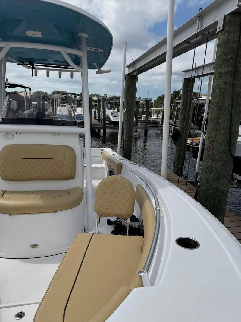 Slide: The Image of 2022 Sportsman Open 212 Center Console boat docked at marina, featuring tan seating. - 7