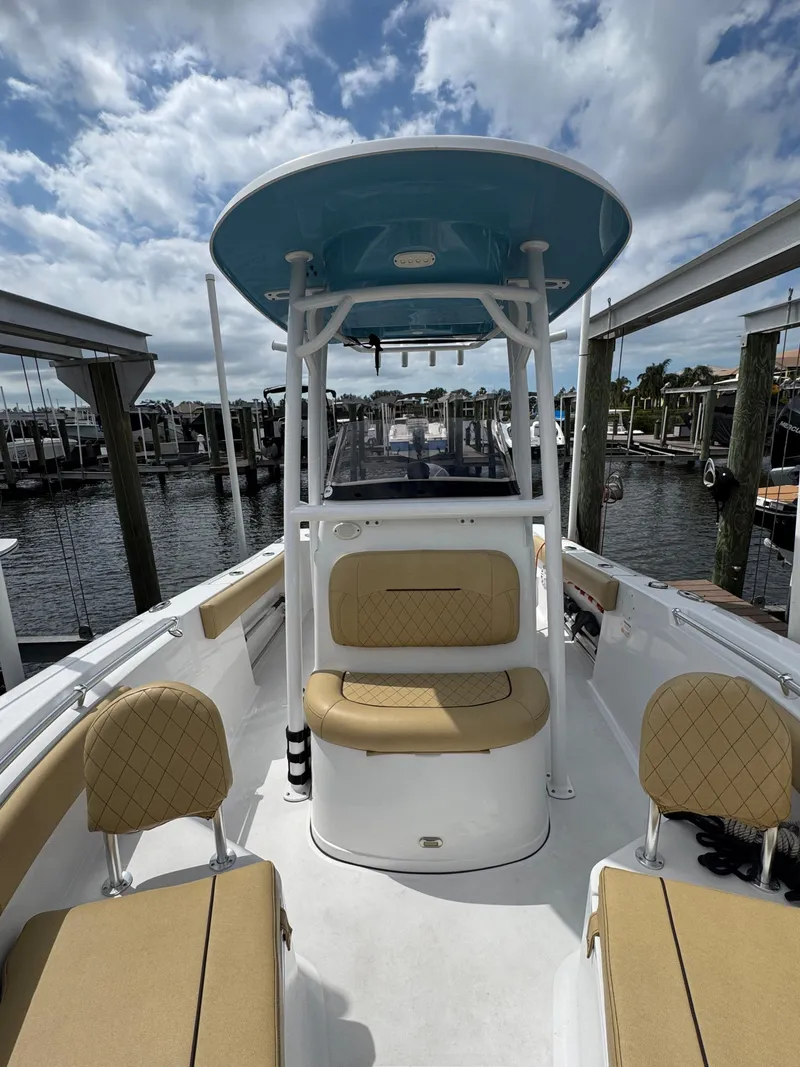 Slide: The Image of 2022 Sportsman Open 212 Center Console boat with tan seating, docked under a cloudy sky. - 8