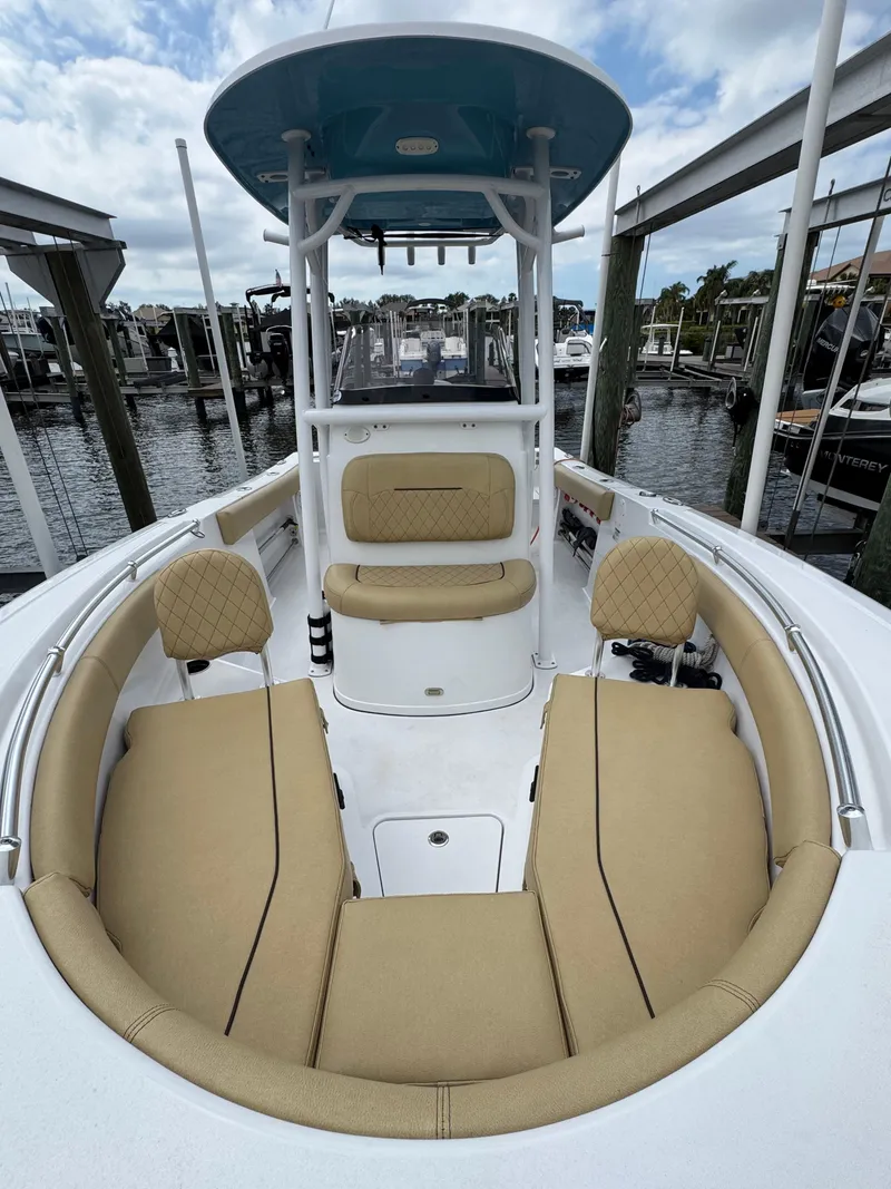 Slide: The Image of 2022 Sportsman Open 212 Center Console boat with tan seating, docked at a marina. - 9