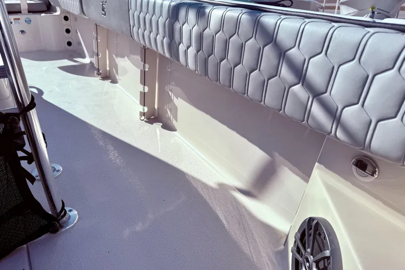 Slide: The Image of 2025 Carolina Skiff 21 Ultra Elite boat interior with storage compartments and motor. - 26