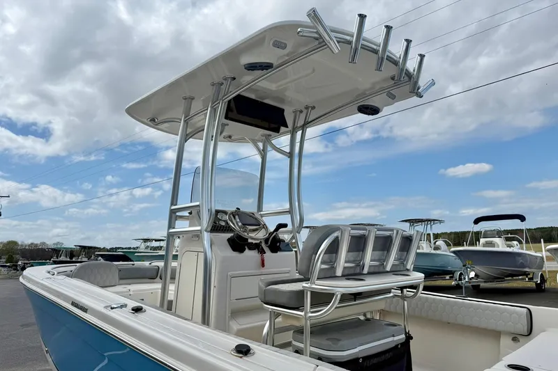 Slide: The Image of 2025 Carolina Skiff 21 Ultra Elite boat with T-top and rod holders under a cloudy sky. - 35