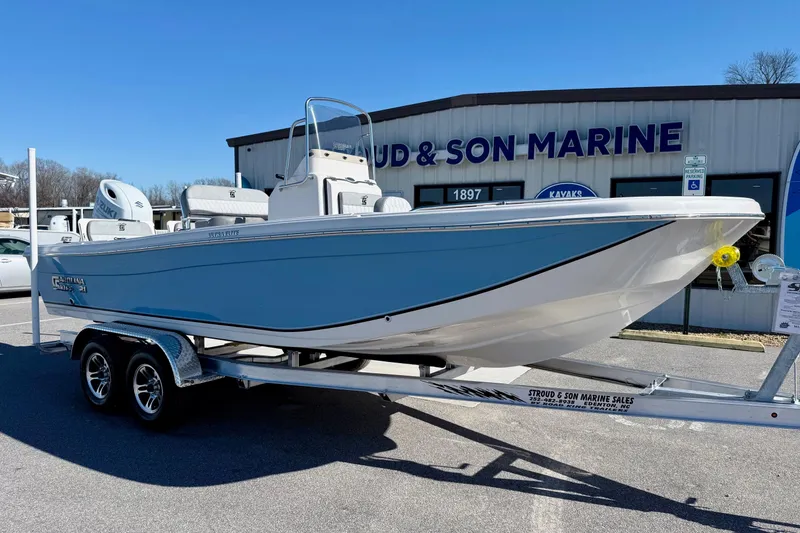 Slide: The Image of 2025 Carolina Skiff 21 Ultra Elite boat on trailer, featuring sleek blue and white design. - 5
