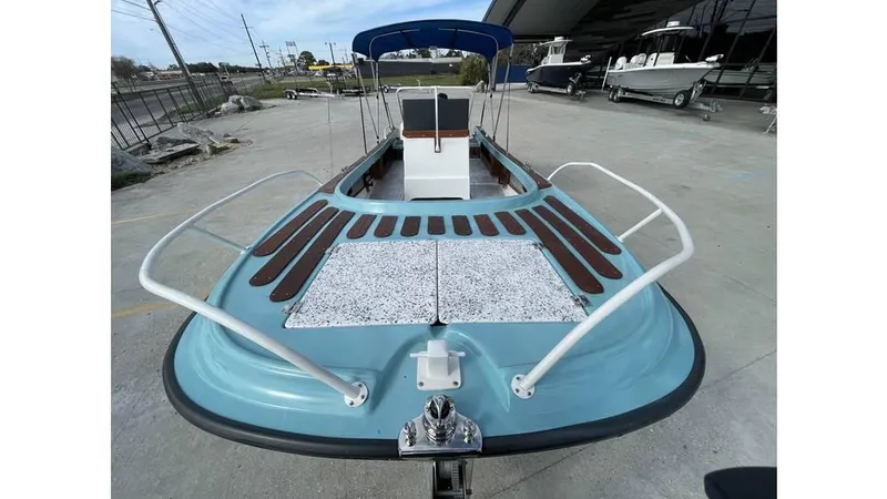 Slide: The Image of 1973 Boston Whaler 21 Outrage boat with blue hull and wooden deck accents. - 10