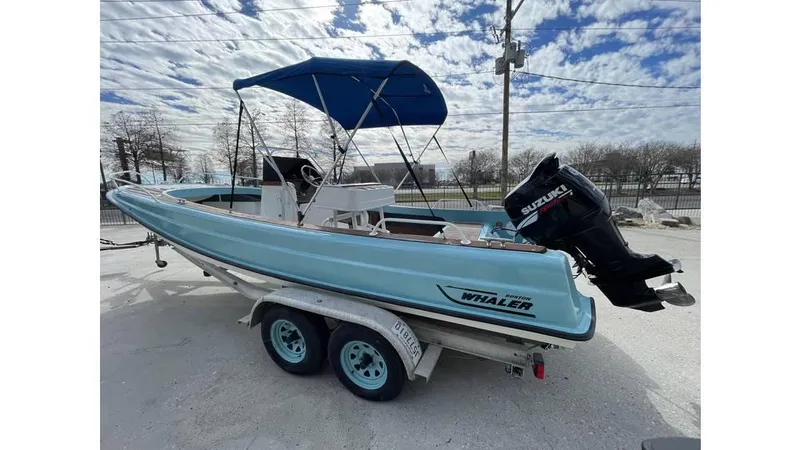 Slide: The Image of 1973 Boston Whaler 21 Outrage boat with Suzuki outboard motor on a trailer. - 3