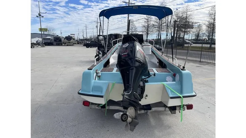 Slide: The Image of 1973 Boston Whaler 21 Outrage boat with outboard motor, parked on a trailer. - 7