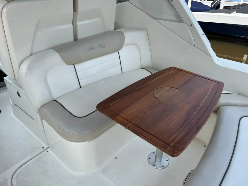 Slide: The Image of 2011 Sea Ray 330 Sundancer interior with cushioned seating and wooden table. - 14