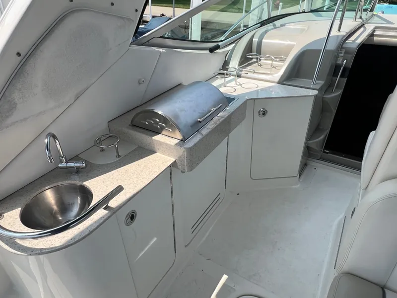 Slide: The Image of 2011 Sea Ray 330 Sundancer boat interior with kitchenette, sink, and grill. - 16